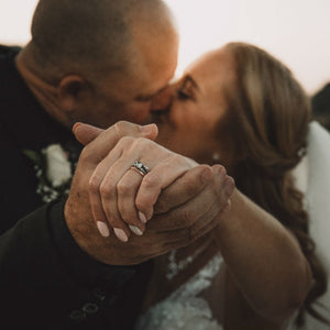 bride wearing princess cut engagement ring kissing groom