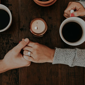 couple holding hands on table