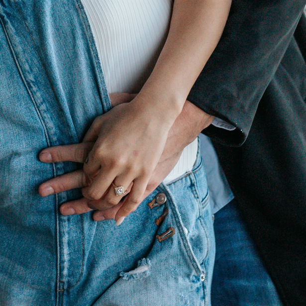 couple holding hands woman wearing engagement ring