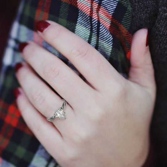 woman's hand wearing a teardrop engagement ring