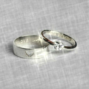 engagement ring and wedding band on grey background