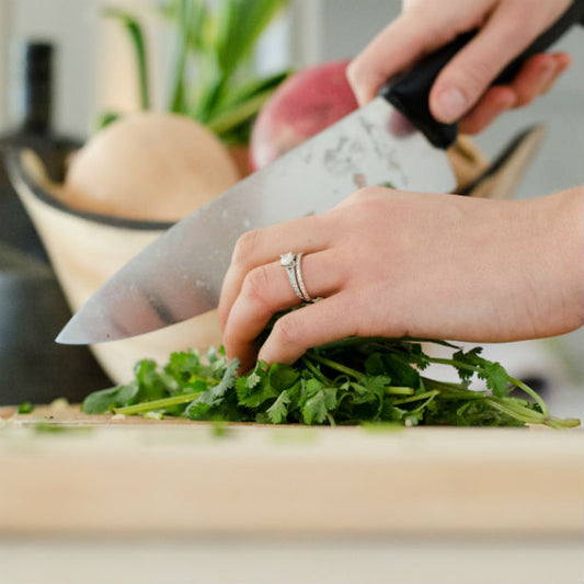 woman chopping herbs wearing engagement ring for chef