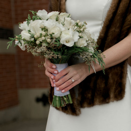 woman holding bouquet wearing thin band engagement ring