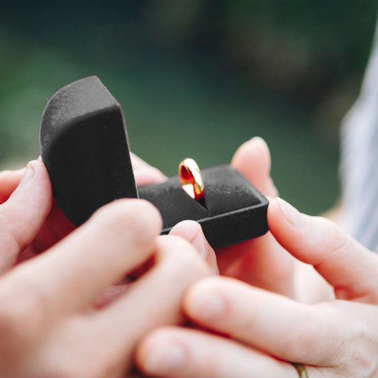 woman proposing to a man with gold band