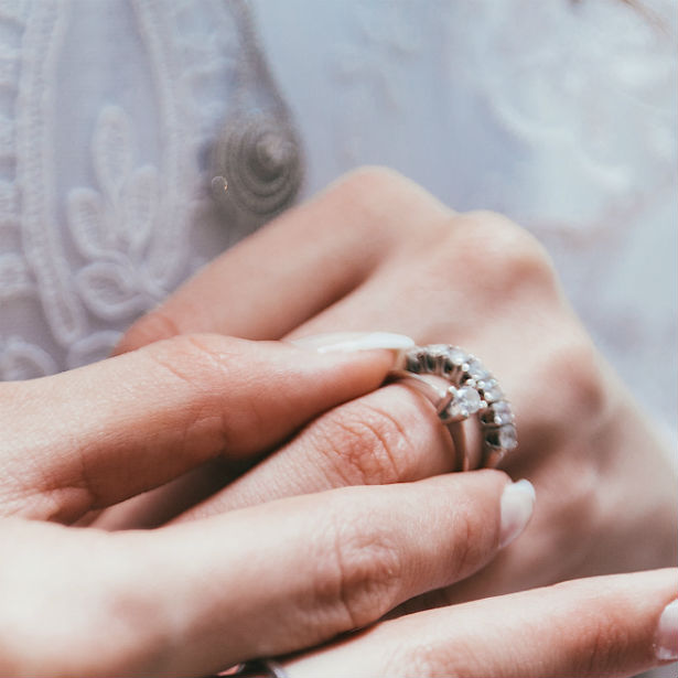 woman sliding simple engagement ring on finger