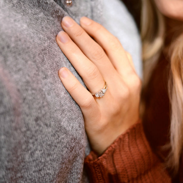 woman touching fiances chest wearing asscher cut engagement ring