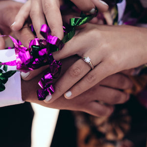 woman wearing princess cut diamond ring holding man's arm