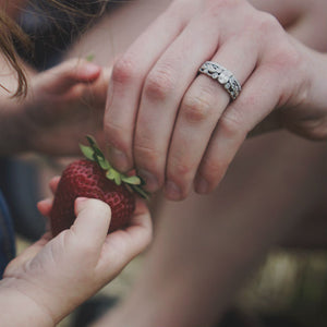 woman wearing victorian style engagement ring grabbing strawberry